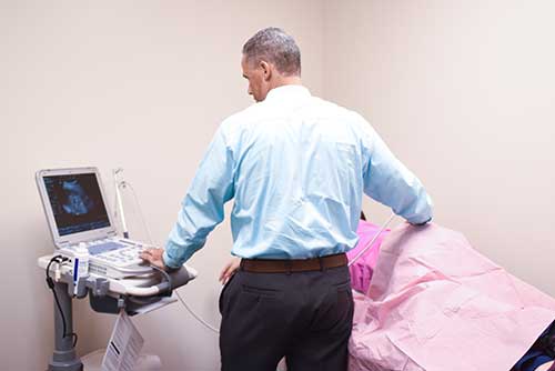 Doctor Performing Ultrasound on Patient